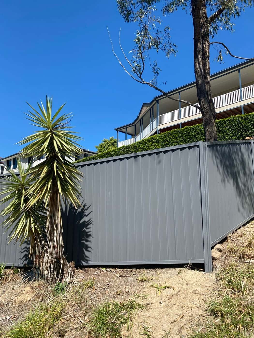 Grey Colorbond fence stepping down a sloping block