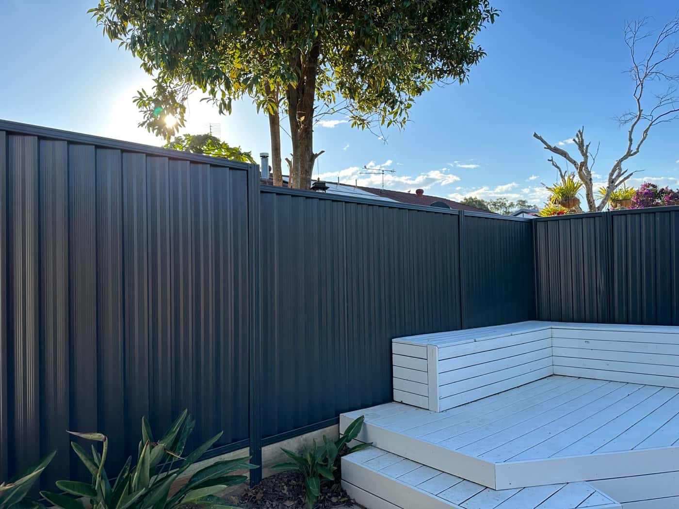 Dark Colorbond fence behind a white timber deck