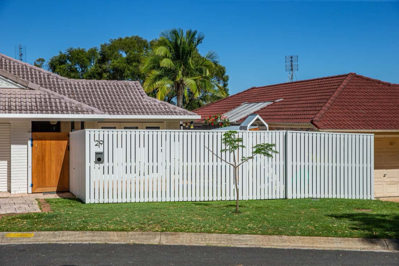 White slat front fence across a house frontage