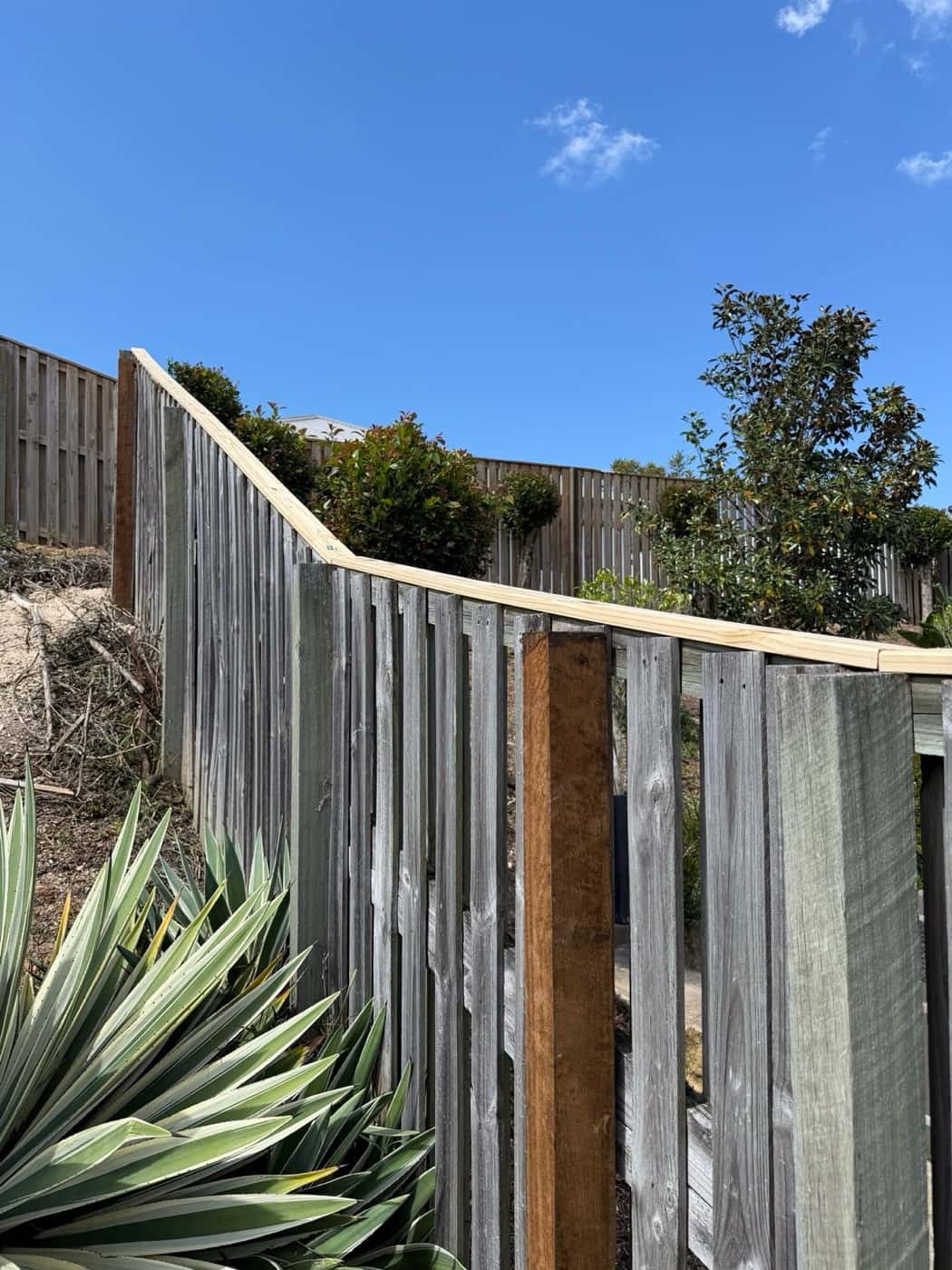 The same sloping fence straight with a new post and capping
