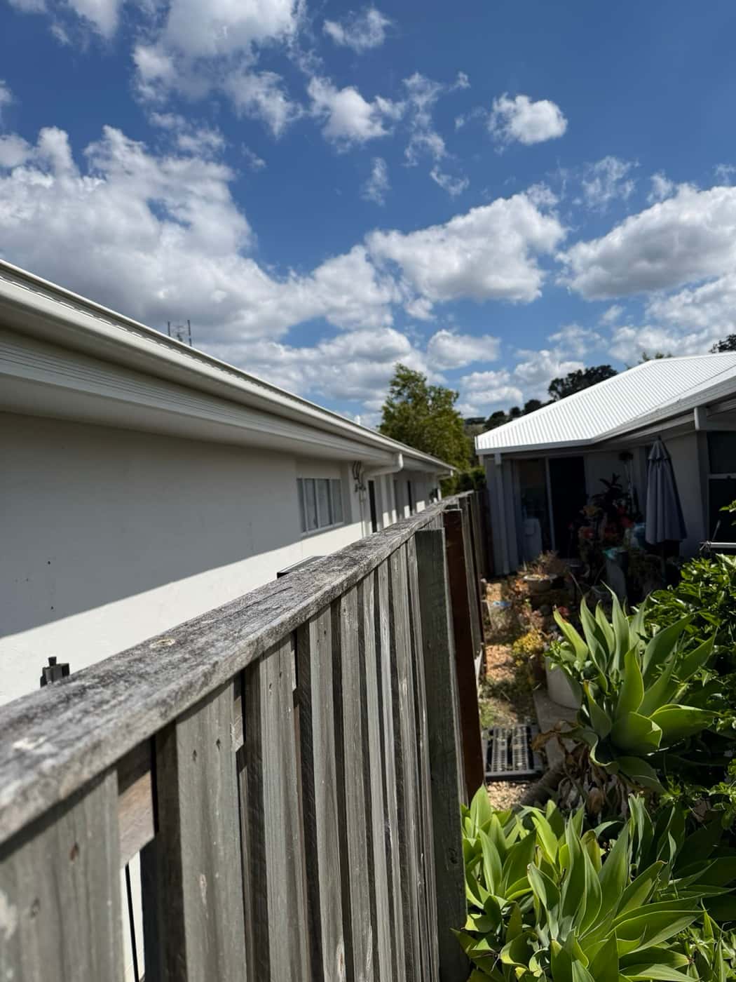 Top rail of a timber fence bowed and leaning before repair