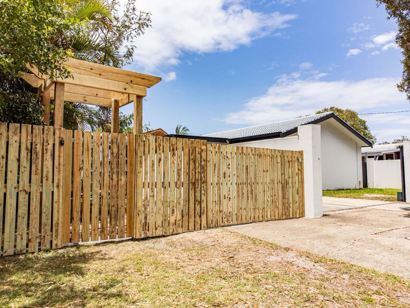 Timber paling fence with a timber arbour entry