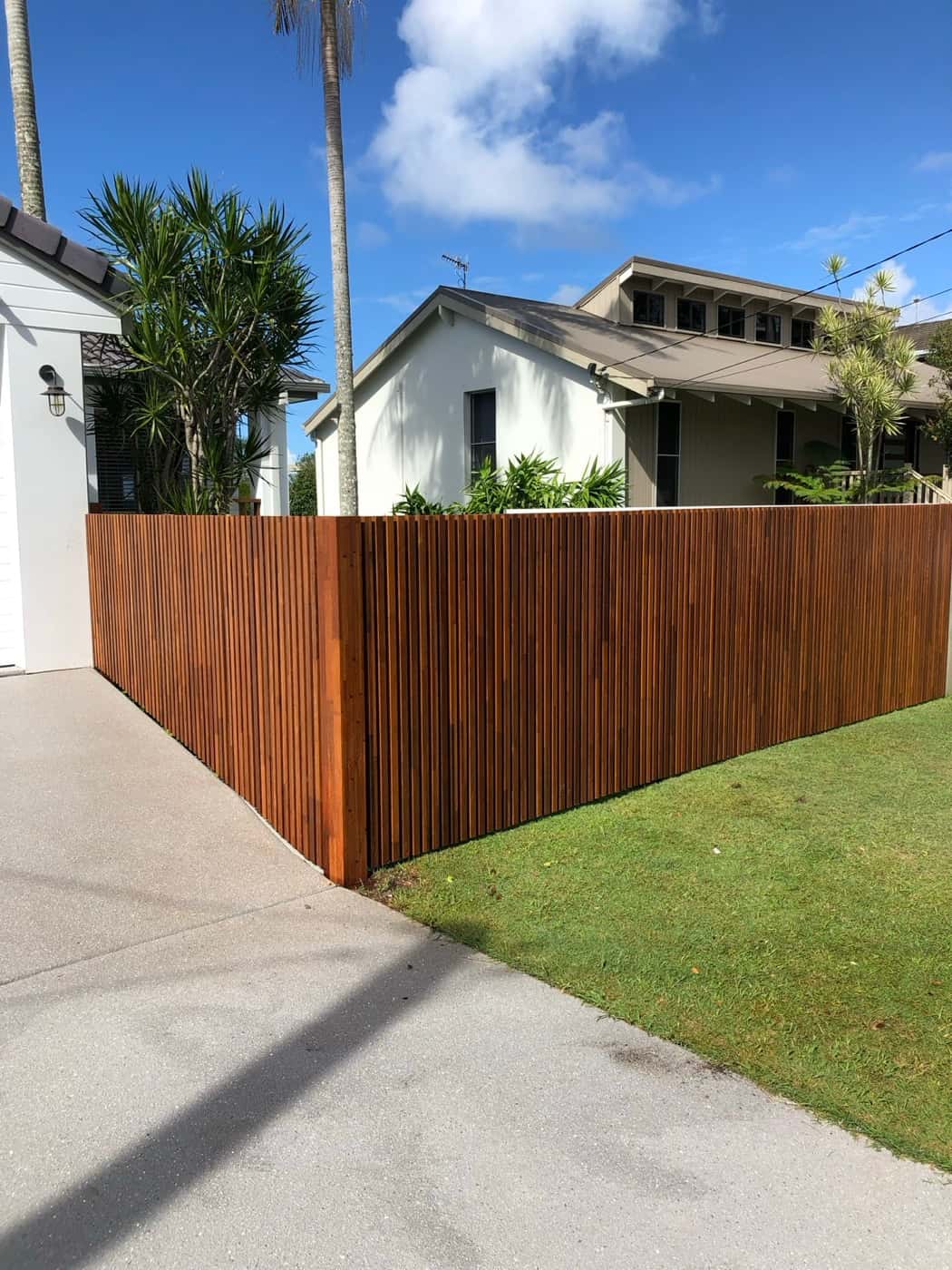 Stained hardwood screen fence beside a driveway