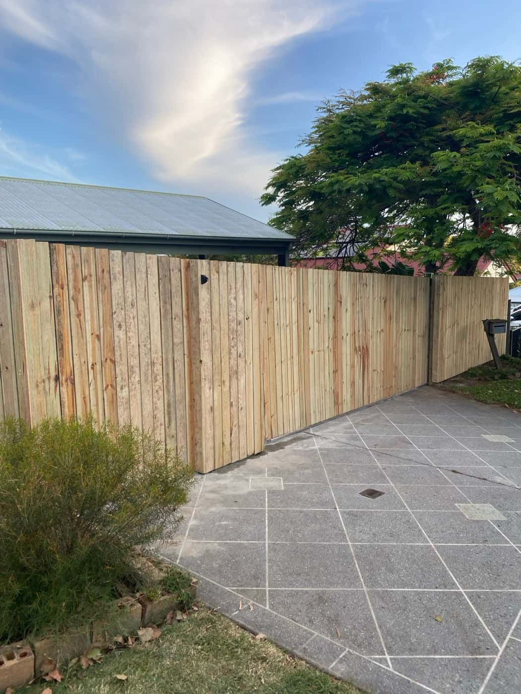 New timber paling fence beside a paved courtyard
