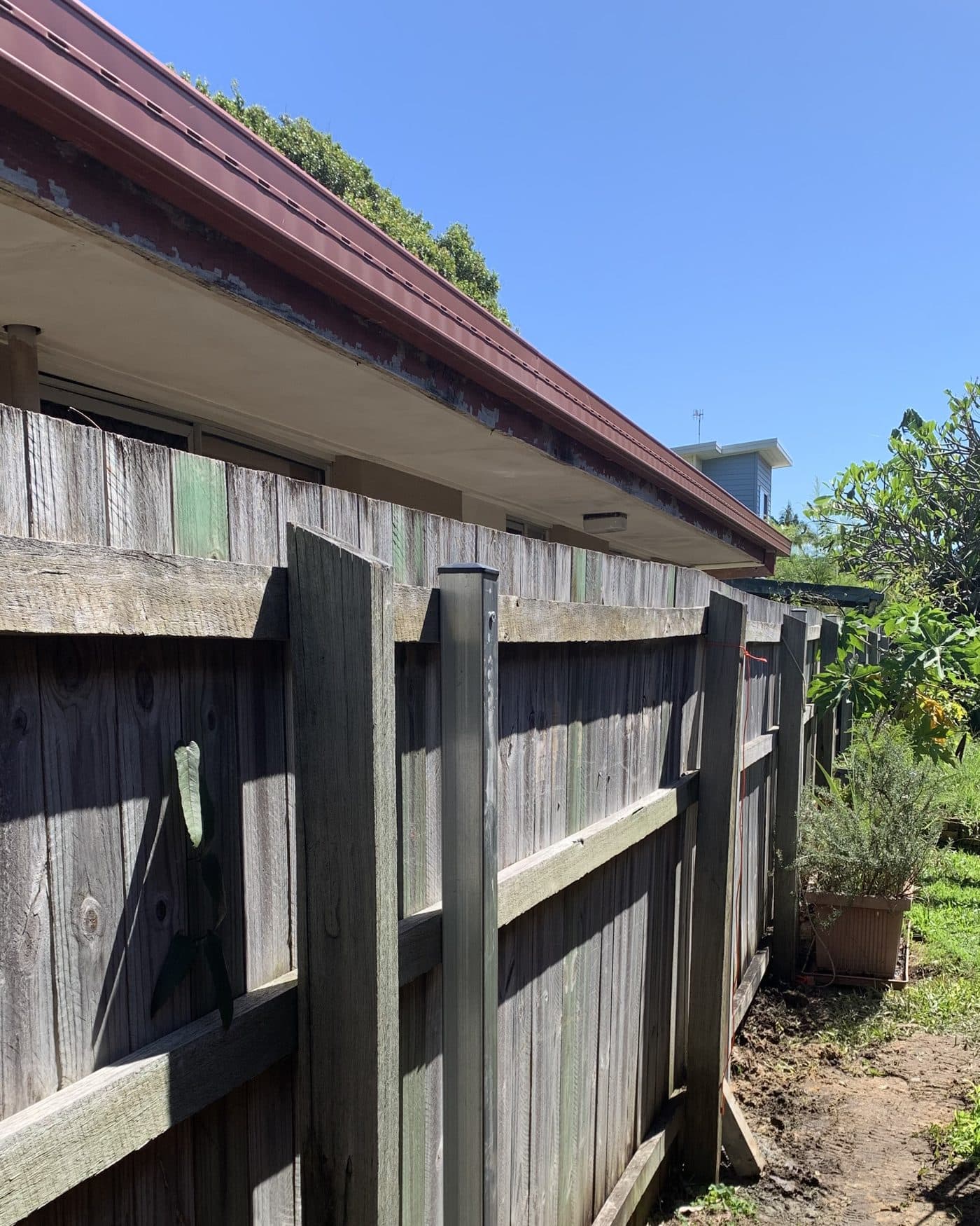 A leaning timber fence on the Gold Coast, straightened on new steel posts by FenceFix